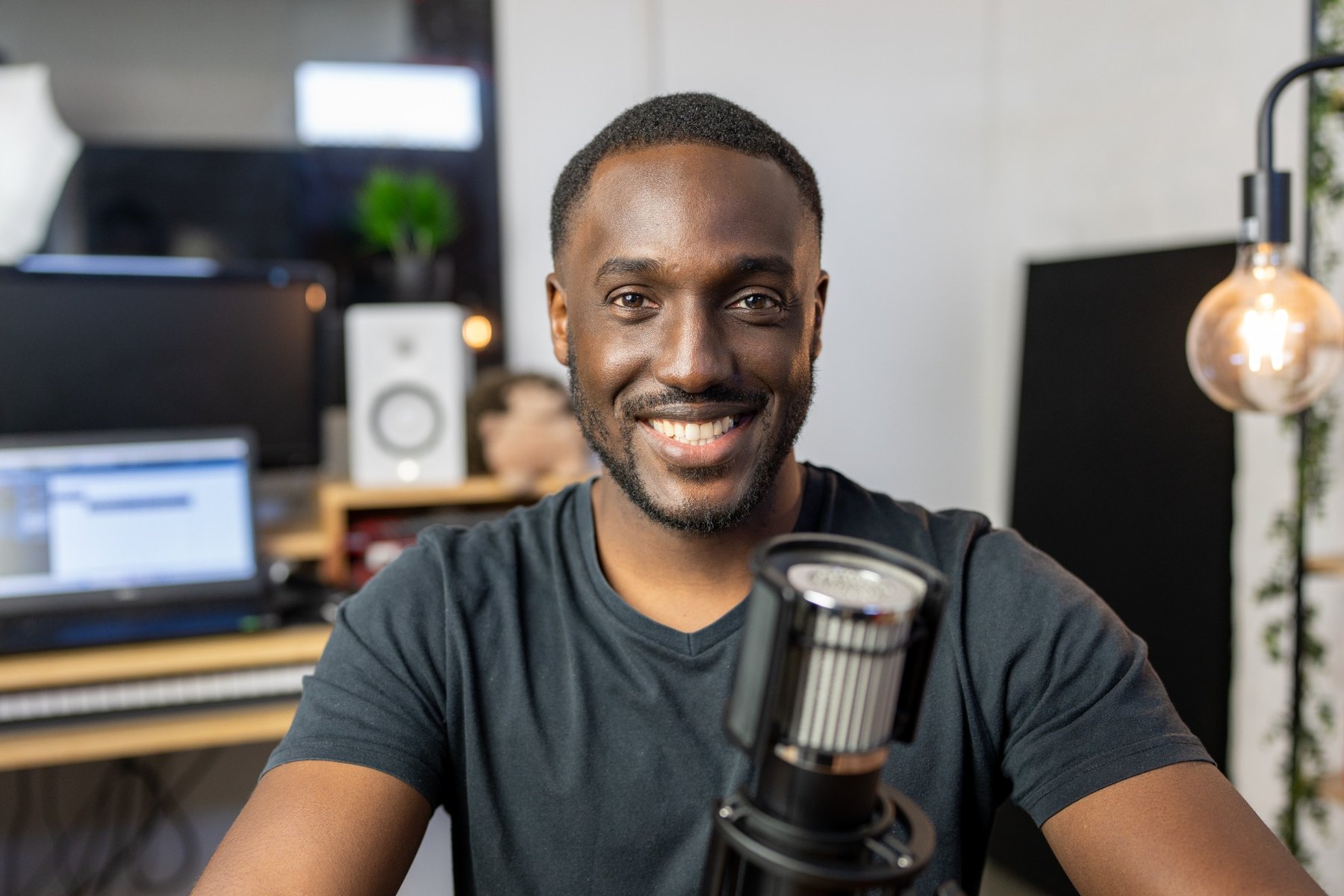 Adrian Silas smiling behind a microphone in his studio