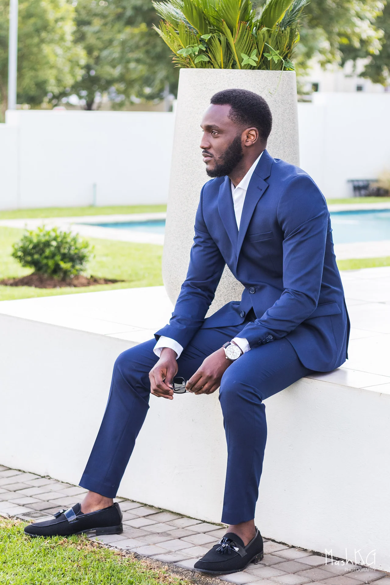Adrian Silas seated outdoors in a navy suit